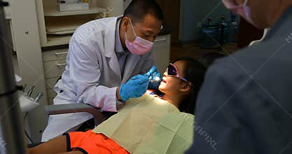 Male dentist examining a patient with tools 4k