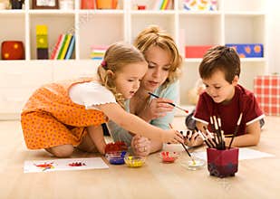 Kids painting hands with their mother