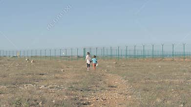 Children walk a dirt path circa in the refugee camp. concept Immigration crisis poor boy and his sister need of help
