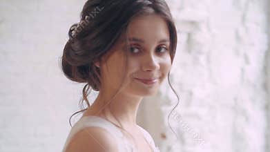 Girl standing at the big window thinking, dark-haired princess decides the fate of her people, in white long gorgeous