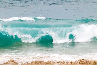 Blue and aquamarine color sea waves and yellow sand  with white foam. Marine beach background.