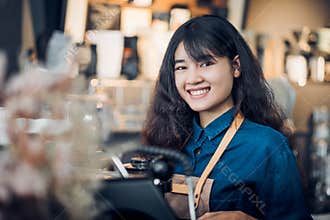 Asian woman barista making hot coffee with machine at counter bar and smile at camera in cafe restaurant,Food and drink service