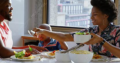 Family having food at dining table in a comfortable home 4k