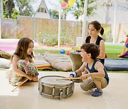 Three kids having fun with drums