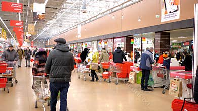 People wander around large supermarket cash-register area