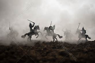 Medieval battle scene with cavalry and infantry. Silhouettes of figures as separate objects, fight between warriors on sunset