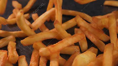 Delicious french fries falling on slate table