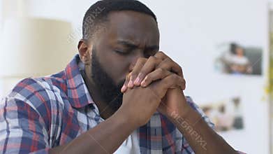 African american man folding hands in prayer, sincere faith in god, religion