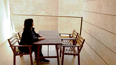 Bricked-up view from the balcony puts a mature adult woman into a depression