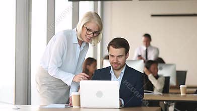 Friendly mature mentor coach executive help employee with computer work