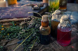 A witchery stuff: multiple tincture bottles, bunches of dry healthy herbs, stack of ancient ritual books, amulets, candles...