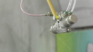 Spray gun with paint in automated production. Action. Close-up automatic with robot hand spray working with painting