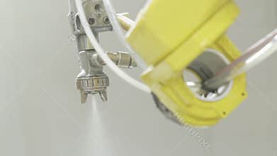 Spray gun with paint in automated production. Action. Close-up automatic with robot hand spray working with painting