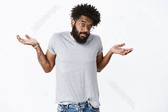 So, not big deal. Portrait of confused and questioned unaware funny african american man shrugging with puzzled look and