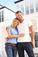 Young Couple Standing Outside Dream Home