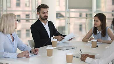 Male team leader or conference participant speaking at group meeting