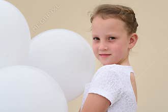 Happy little girl with blue and white balloons.