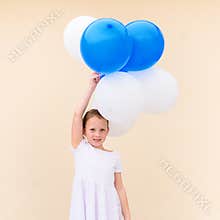 Happy little girl with blue and white balloons.