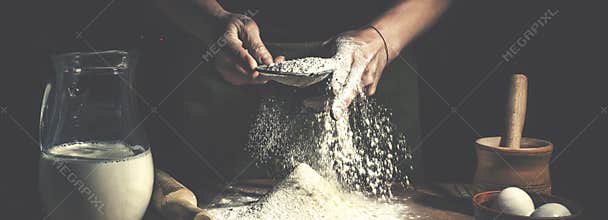 Man preparing bread dough on wooden table in a bakery close up. Preparation of Easter bread.