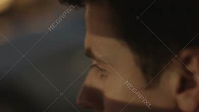 Closeup of tired man driving car at night. Dangerous maniac looking for victim