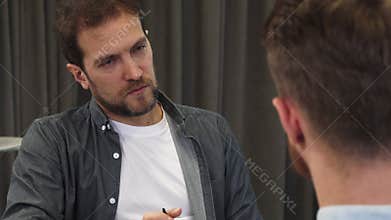 Close up of a mature businessman listening attentively to his colleague at the meeting