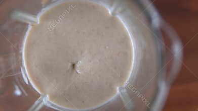 Blending banana smoothie with oatmeal in blender