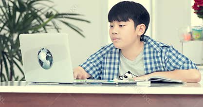 Little asian pre teen doing homework at home with smile face