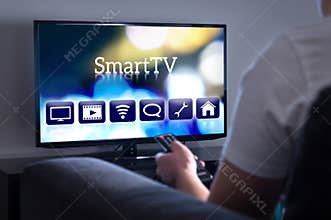 Man watching smart tv. Choosing movie or series from the menu.