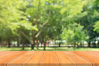 Wooden board empty table in front of blurred background. Perspective brown wood table over blur trees in forest background.