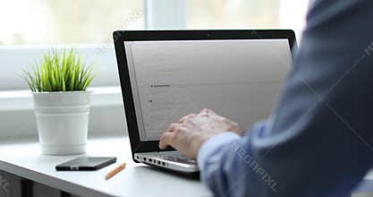 Programmer working on laptop in office writing programming code
