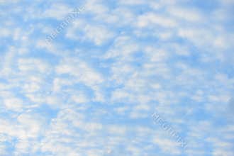 Blue sky with fluffy clouds, close-up background