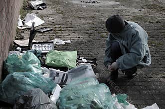 Poor boy searching in the garbage