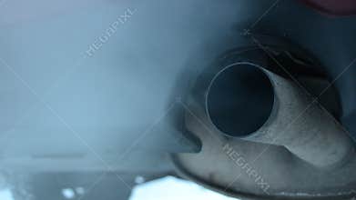 Exhaust coming out from tailpipe on a idling parked car