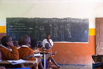 Children in uniforms in primary school classroom listetning to teacher in rural area near Arusha, Tanzania, Africa.