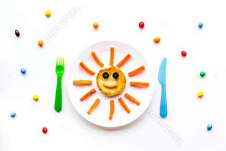 Creative approach to kid`s braekfast. Meal with cheesecake in shape of sun. White background top view