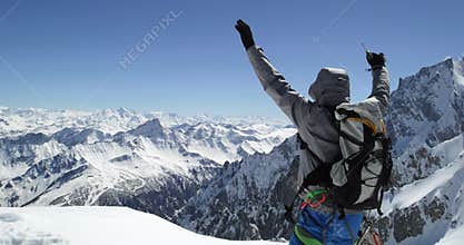 Climber mountaineer man reaching snowy mount top with ice axe in sunny day.Mountaineering ski activity. Skier people