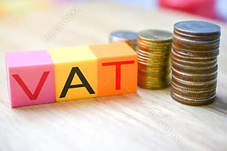 Growing taxes - colour blocks with VAT and money stacks