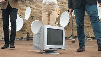 Two men and a girl in suits go to the monitor to break it. A hammer, a bat, violence, hatred, anarchy, destruction. 60