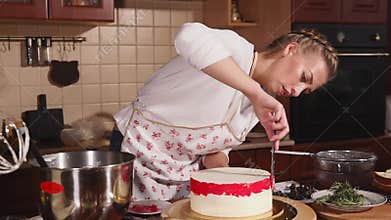 Female cook is glazing cake