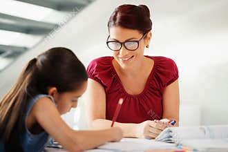 Education With Mom Helping Daughter Doing School Homework At Home