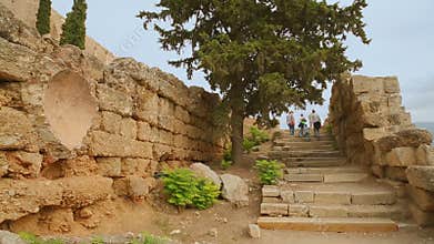 Group of tourists walking upstairs, sightseeing tour to ruins of ancient building