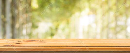Wooden board empty table blurred background. Perspective brown wood table over blur trees forest background.