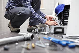 Hands plumber at work in a bathroom, plumbing repair service, as