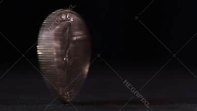 A quarter USD coin spinning on table