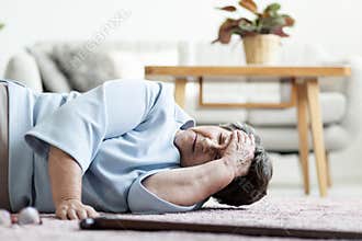 Senior woman with a headache after falling down at home