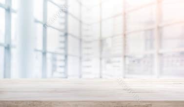 Wood table top on blur white glass window background form office