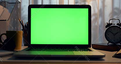 Laptop with green screen. Dark office. Dolly move right to left. Perfect to put your own image or video.Green screen of technology