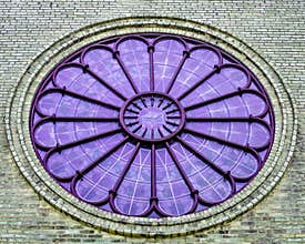 Round Purple Stained Glass Window with Monochrome Bricks