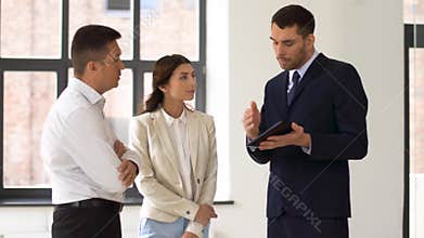 Realtor showing tablet pc to customers at office