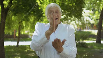 Old deaf-mute woman saying in sign language - hear us, we are and we love you